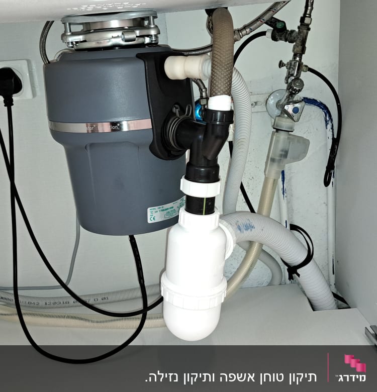 מערכת צינורות מתחת לכיור עם טוחן אשפה